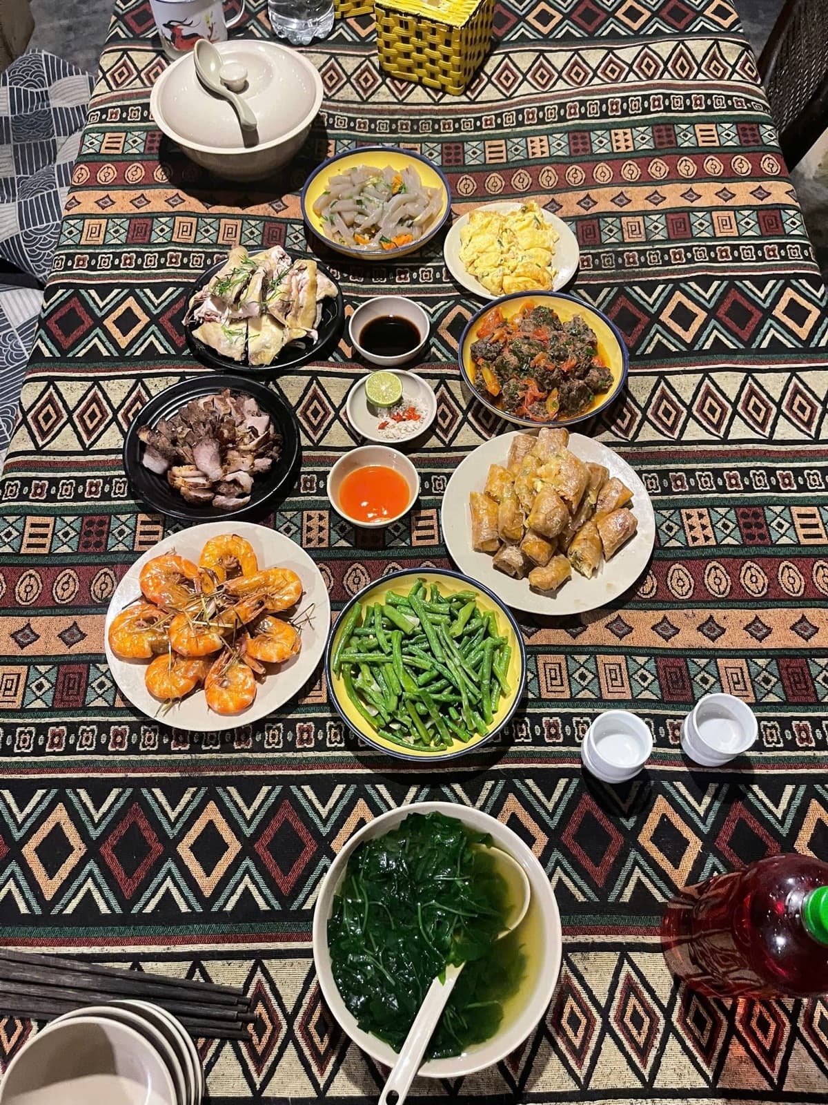 Home-cooked dishes on a table with a woven local cloth
